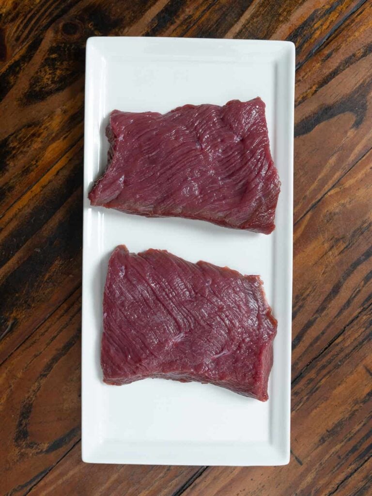 Venison steak cut in half for tartare.