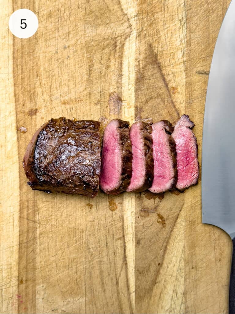 Sliced steak on a cutting board.