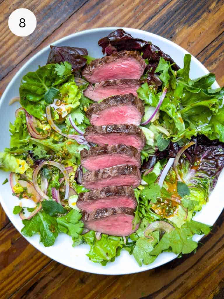 Thai steak salad in a white bowl.