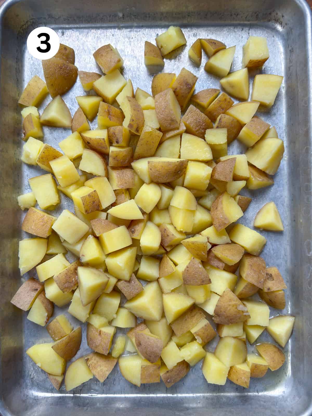 Par cooked potatoes cooling on a baking pan.