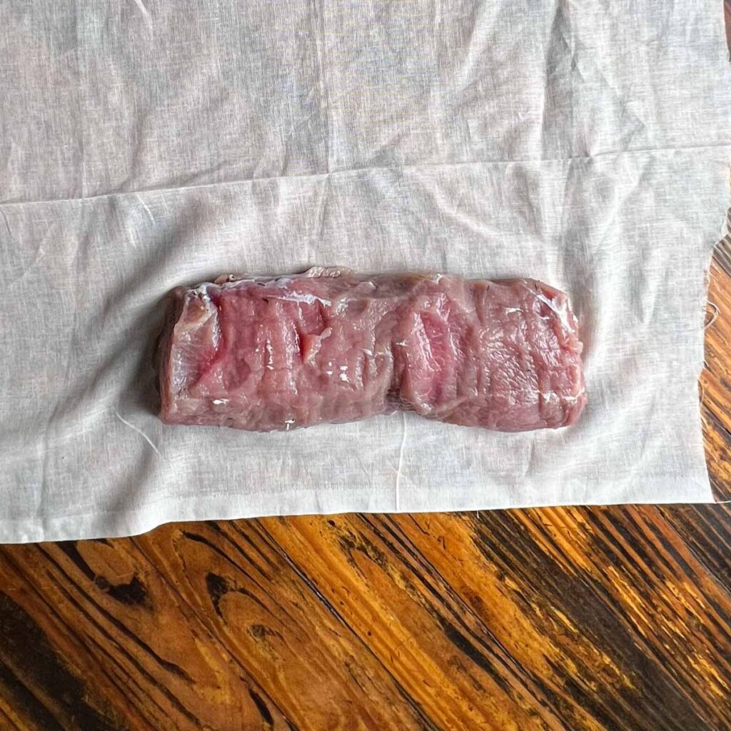 Pork loin on cheesecloth.