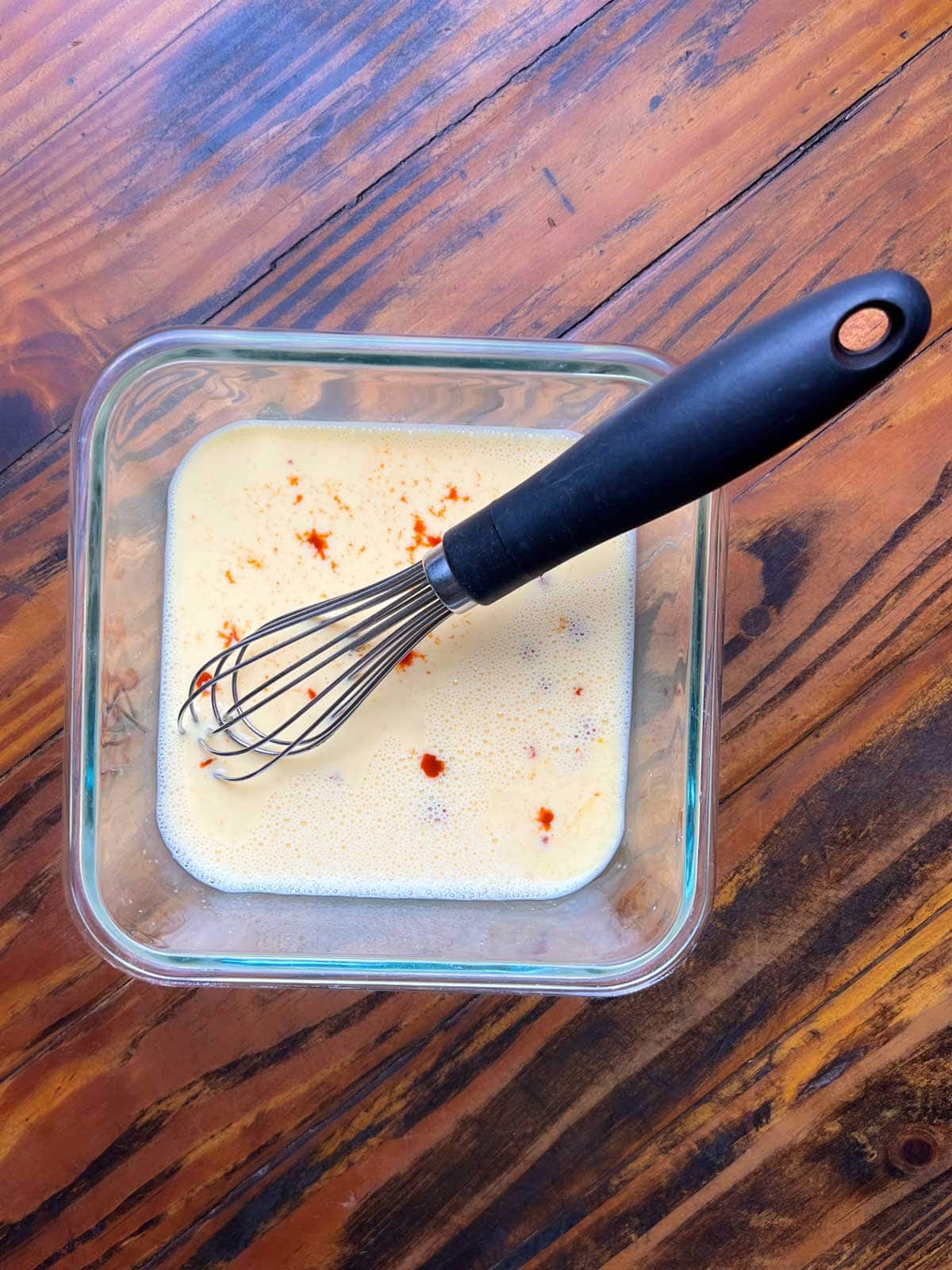 Thai-Fish-Sauce-Dressing Egg wash for breading catfish in a glass dish with a whisk resting in it