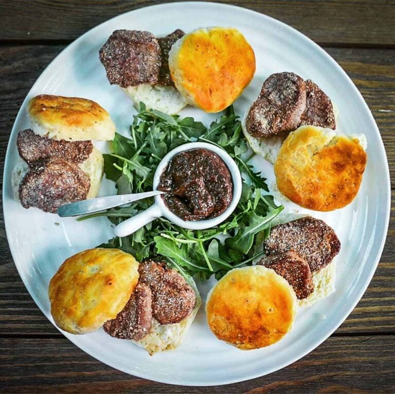 Fried venison backstrap on a plate with biscuits.