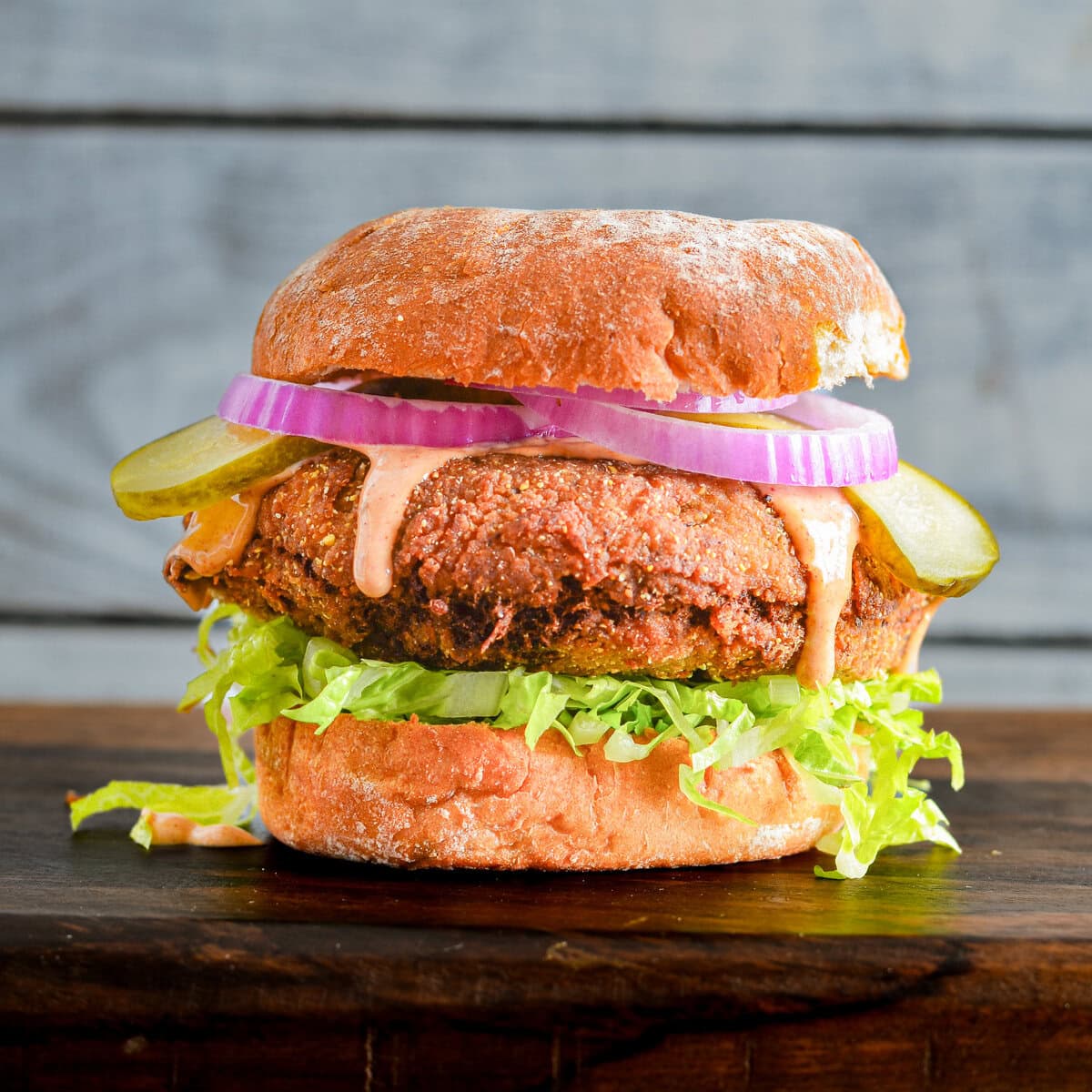 Fried boudin ball sandwich on a wooden board.