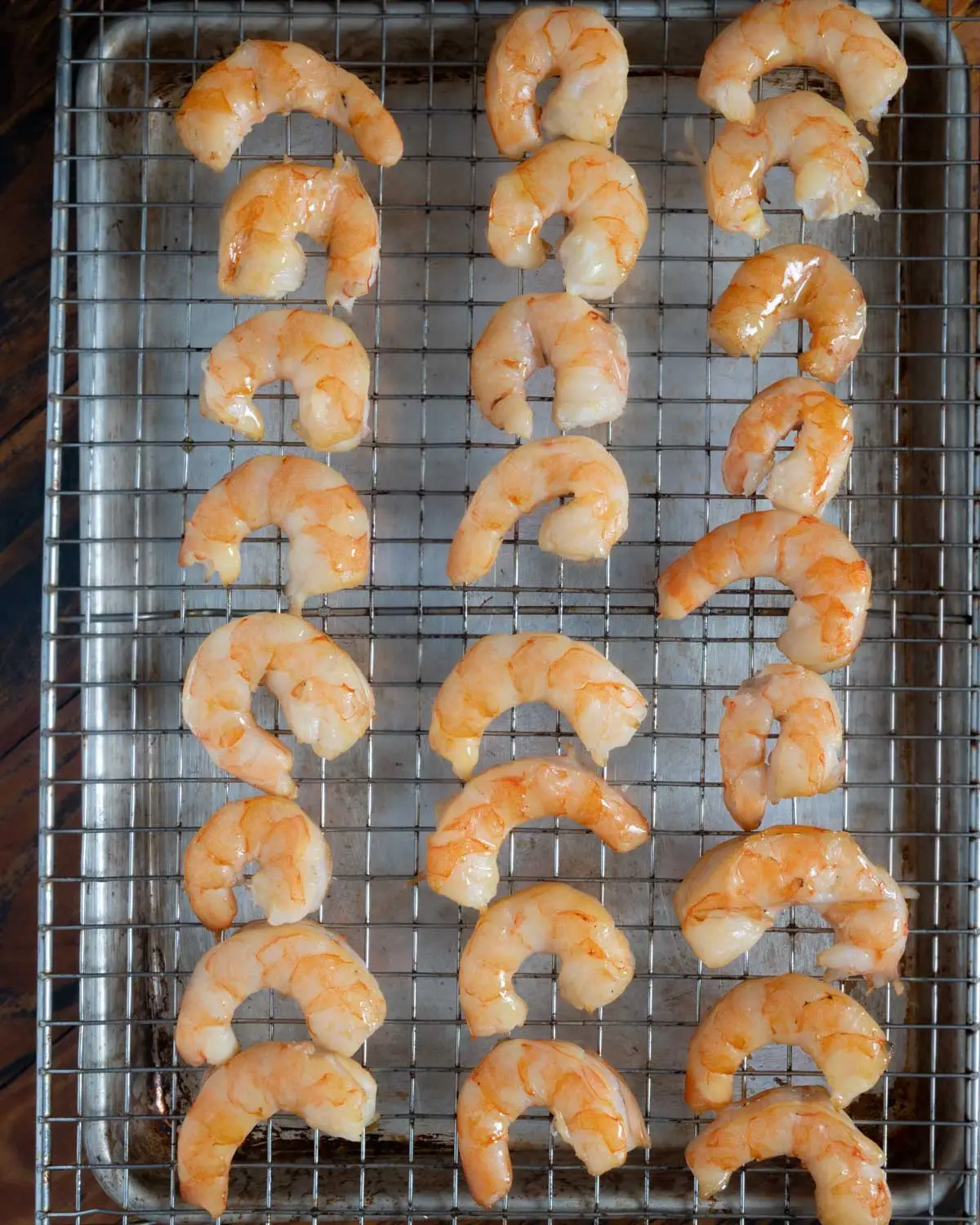 Smoked shrimp laying on a baking rack.