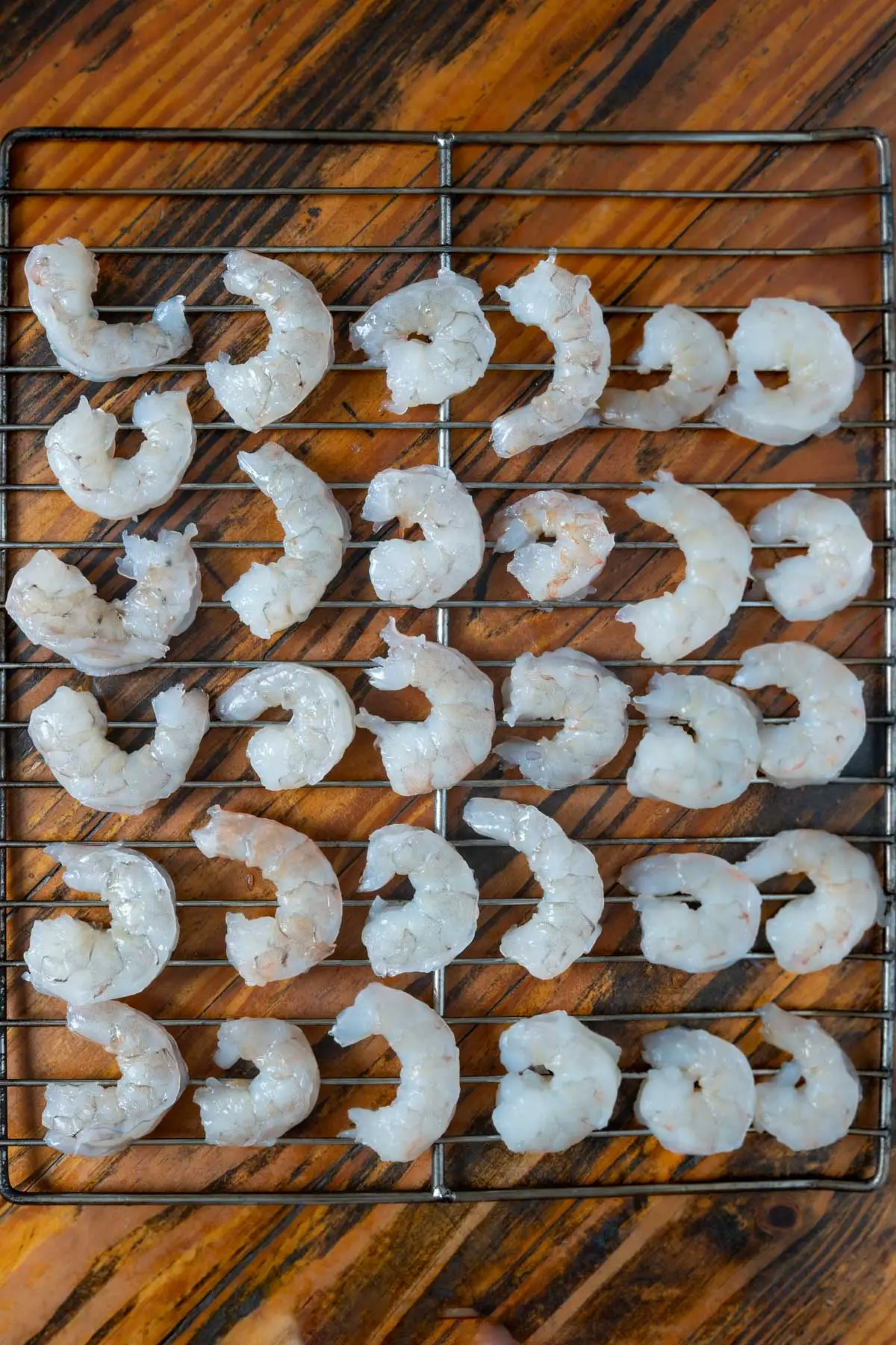 Brined shrimp laying on a smoker rack.