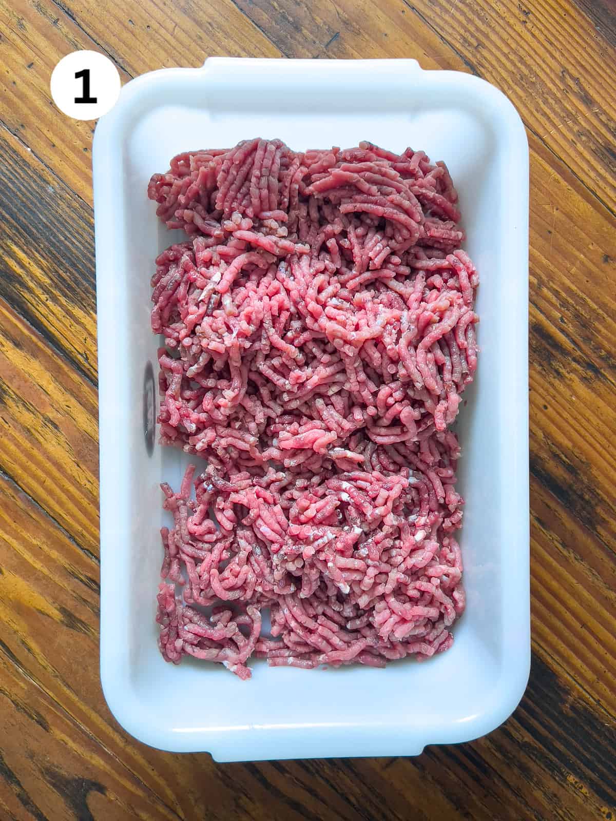 Ground venison in a small white meat tub.