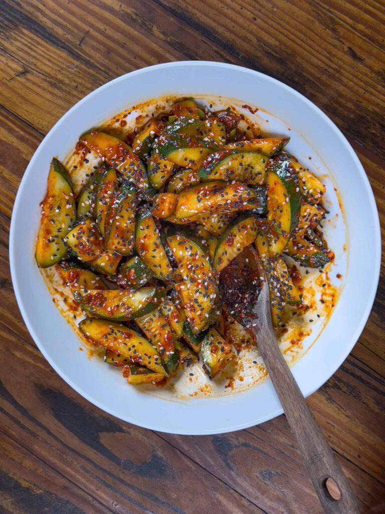 topping the cucumbers with toasted sesame seeds
