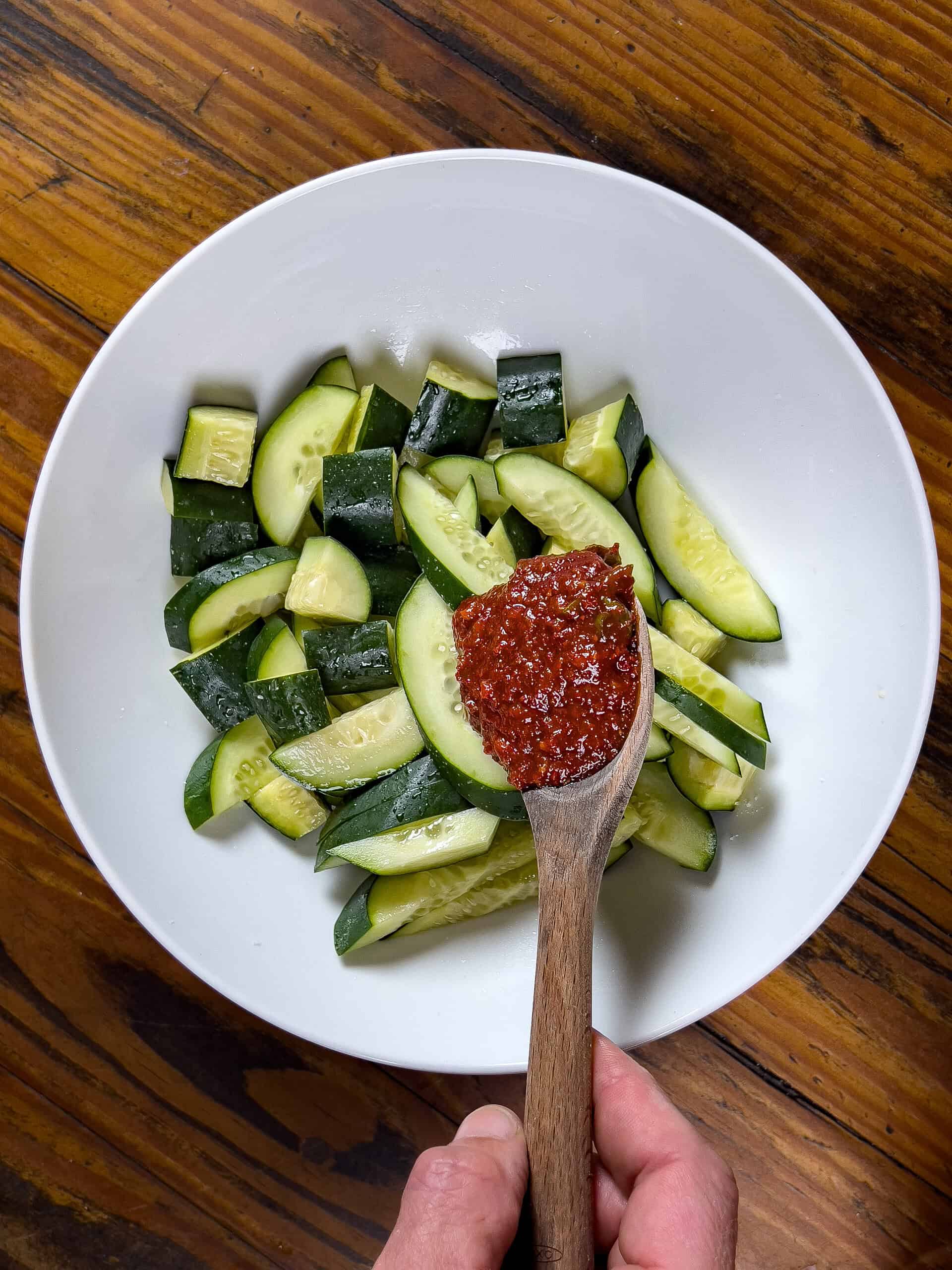 Adding chili paste to the cucumbers
