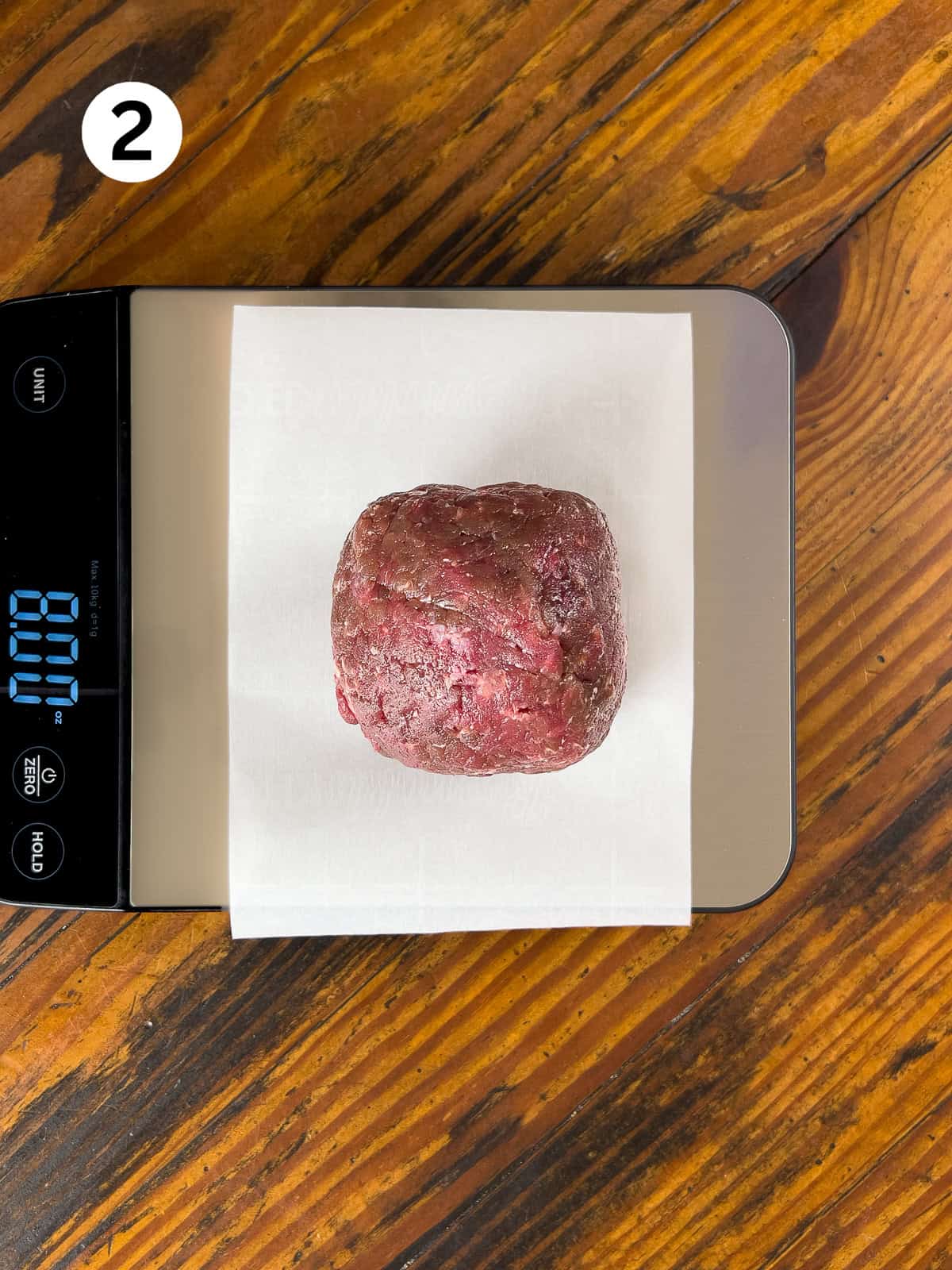 Raw venison burger on a scale.