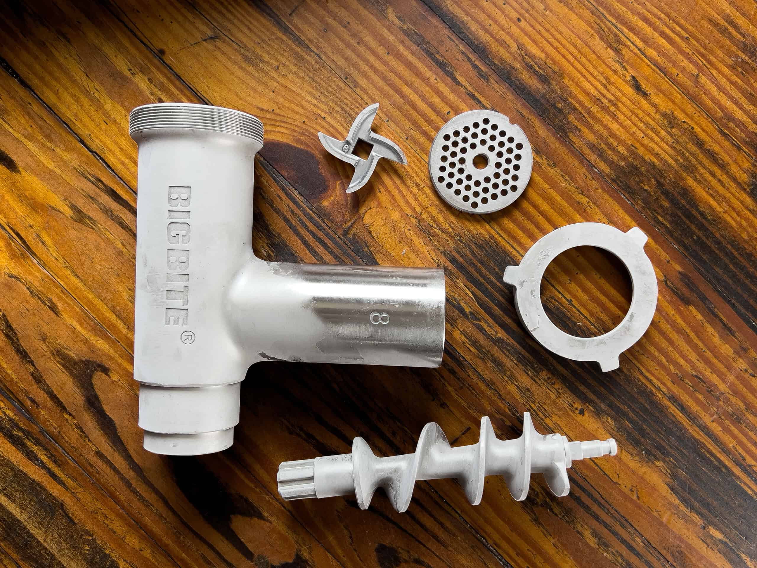 Chilled meat grinder parts on a table.