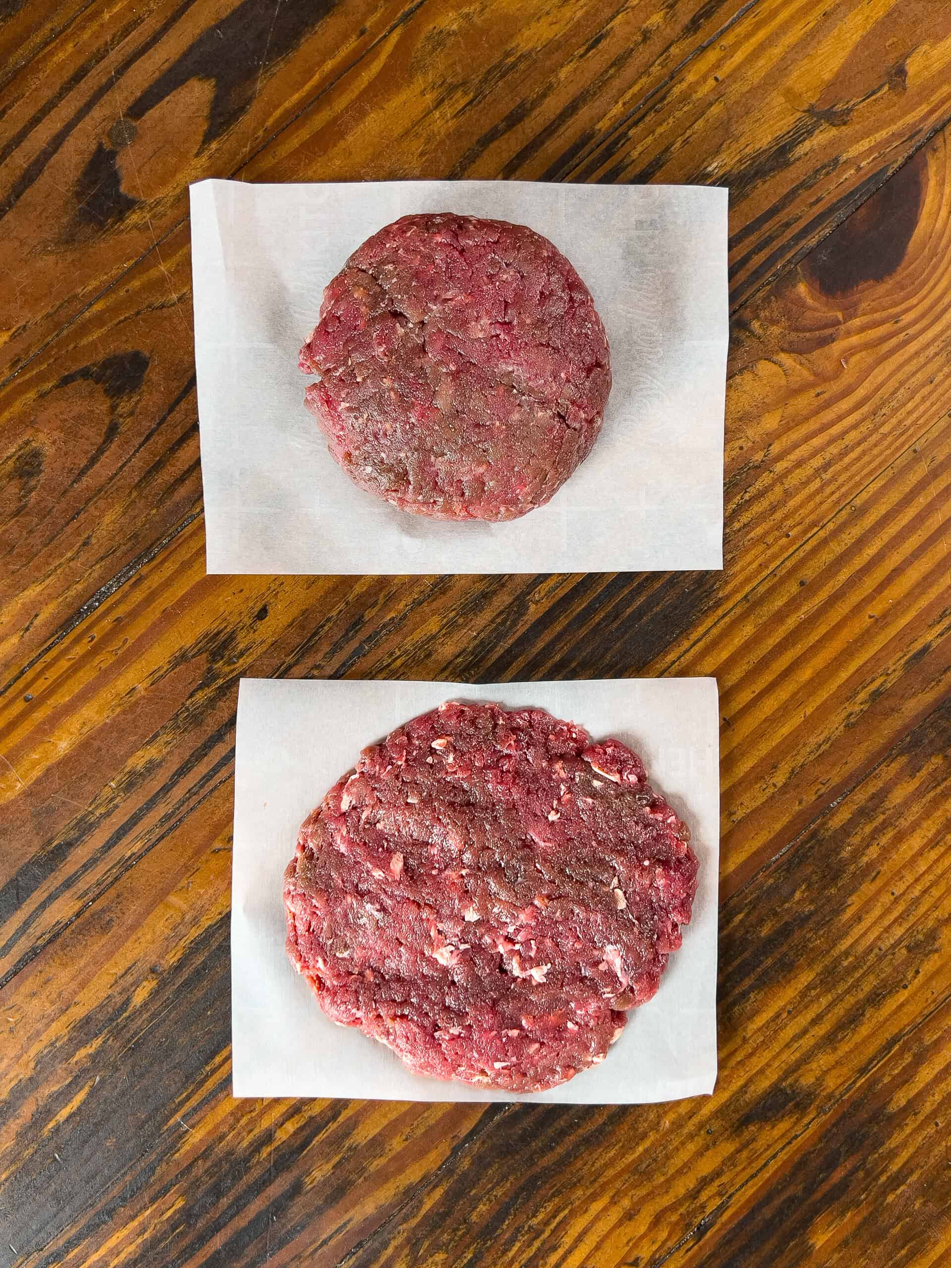 Venison burger patties on parchment paper.