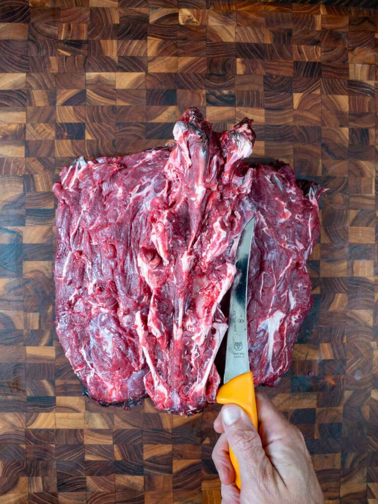 Cutting just under the deers spine in the neck