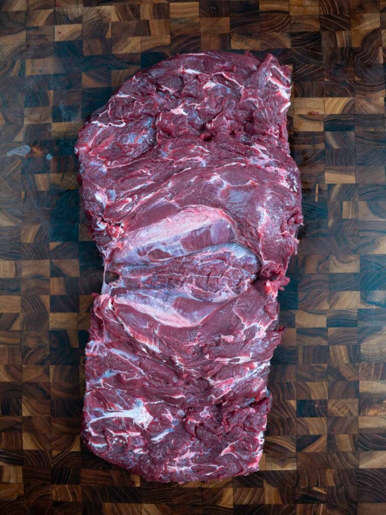 Boneless neck lying vertically on the cutting board.