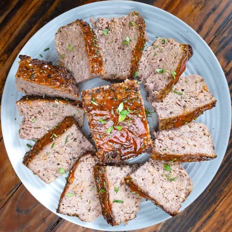 Slices of venison meatloaf on a white plate.