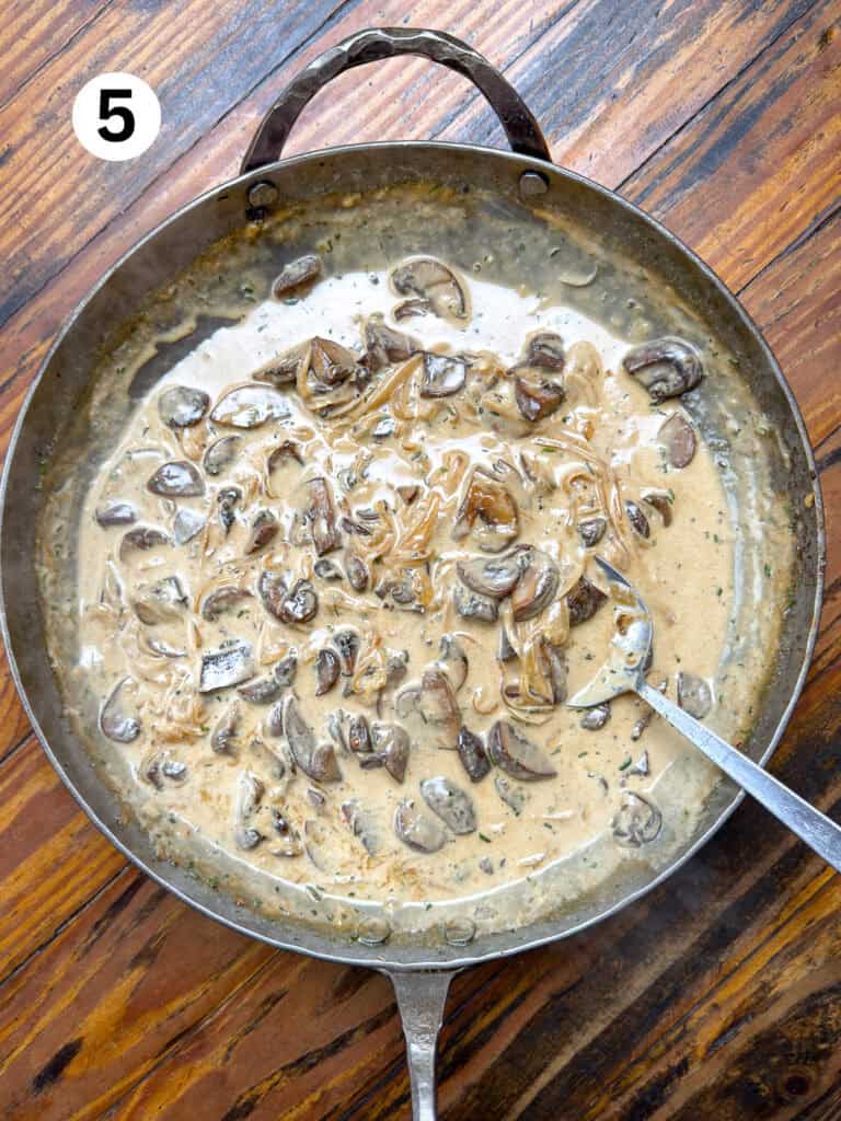 Mushrooms, onions, cream, stock and herbs in a carbon steel pan.