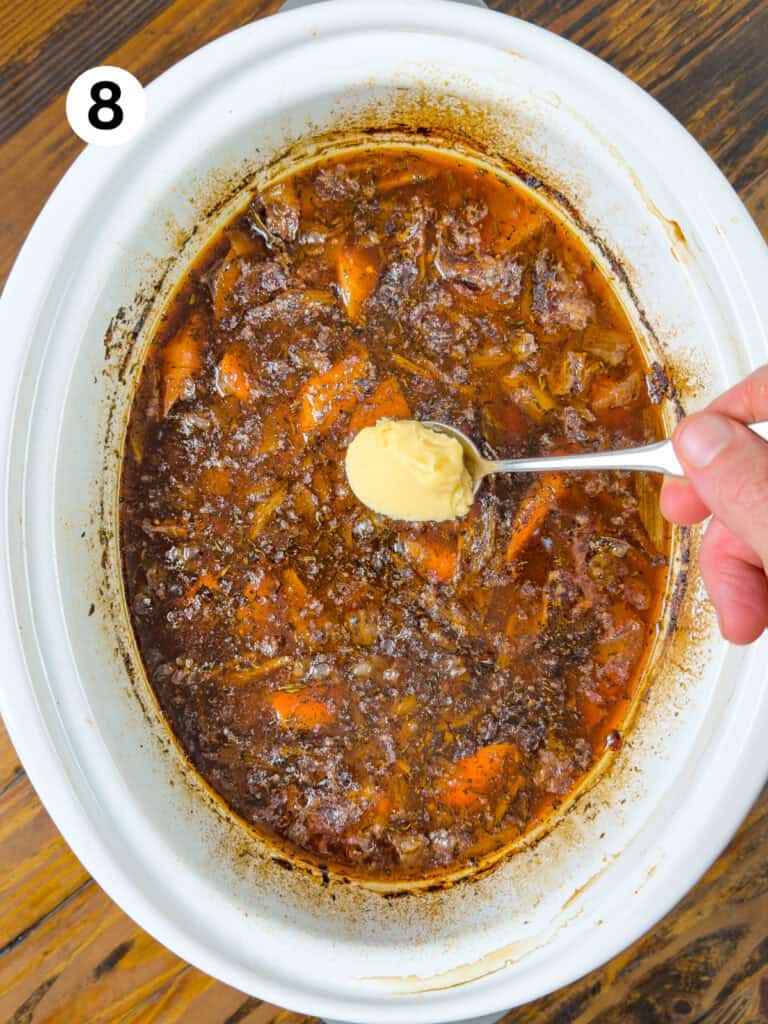 Adding butter and flour to venison stew in a slow cooker.