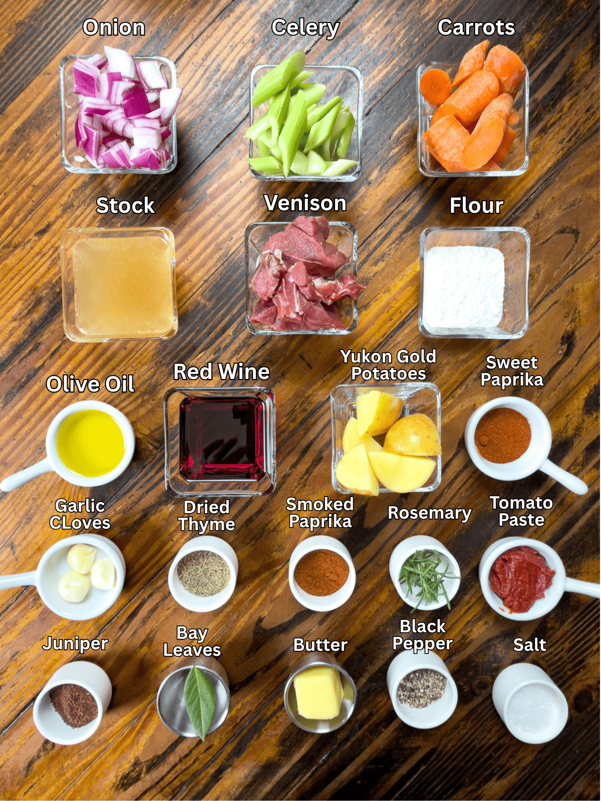 Ingredients for slow cooker venison stew on a wooden table.