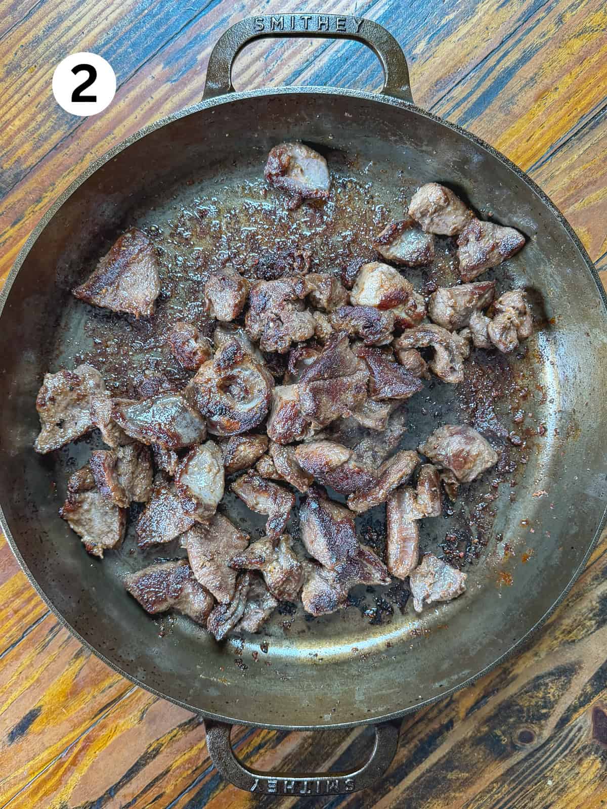 Seared venison in a cast iron pan.
