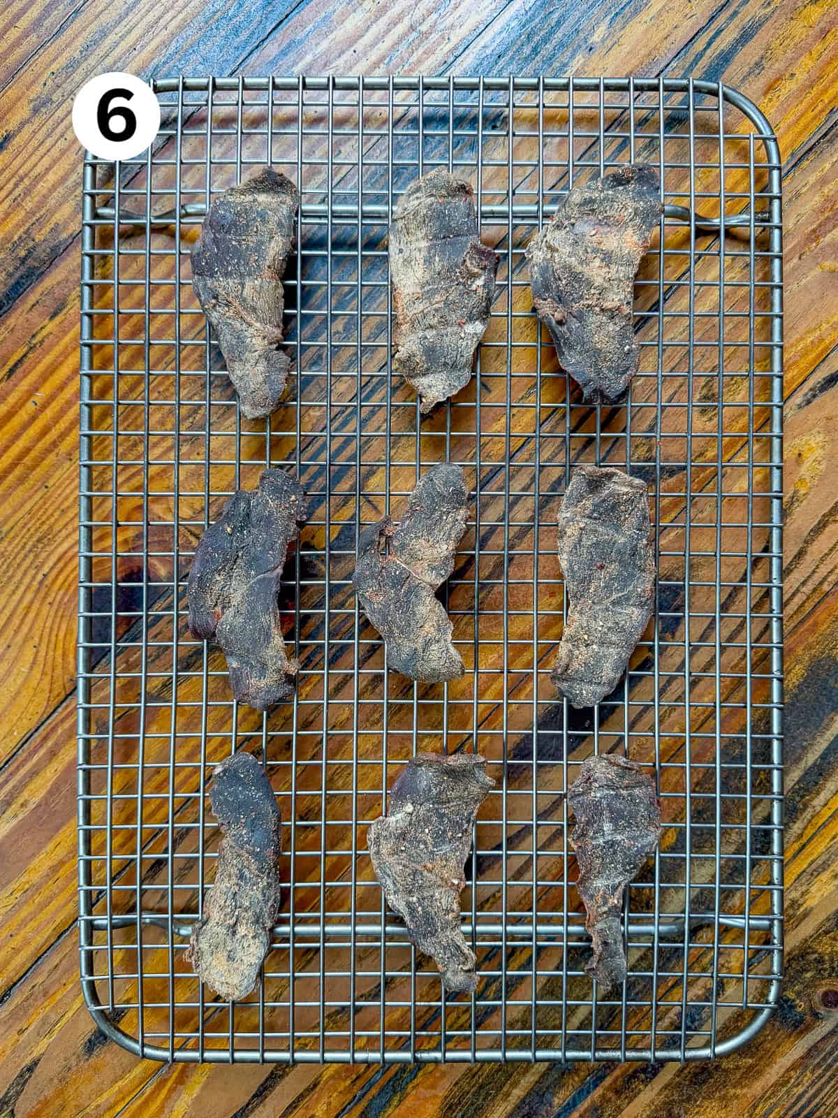 Smoked venison jerky cooling on a wire baking rack.