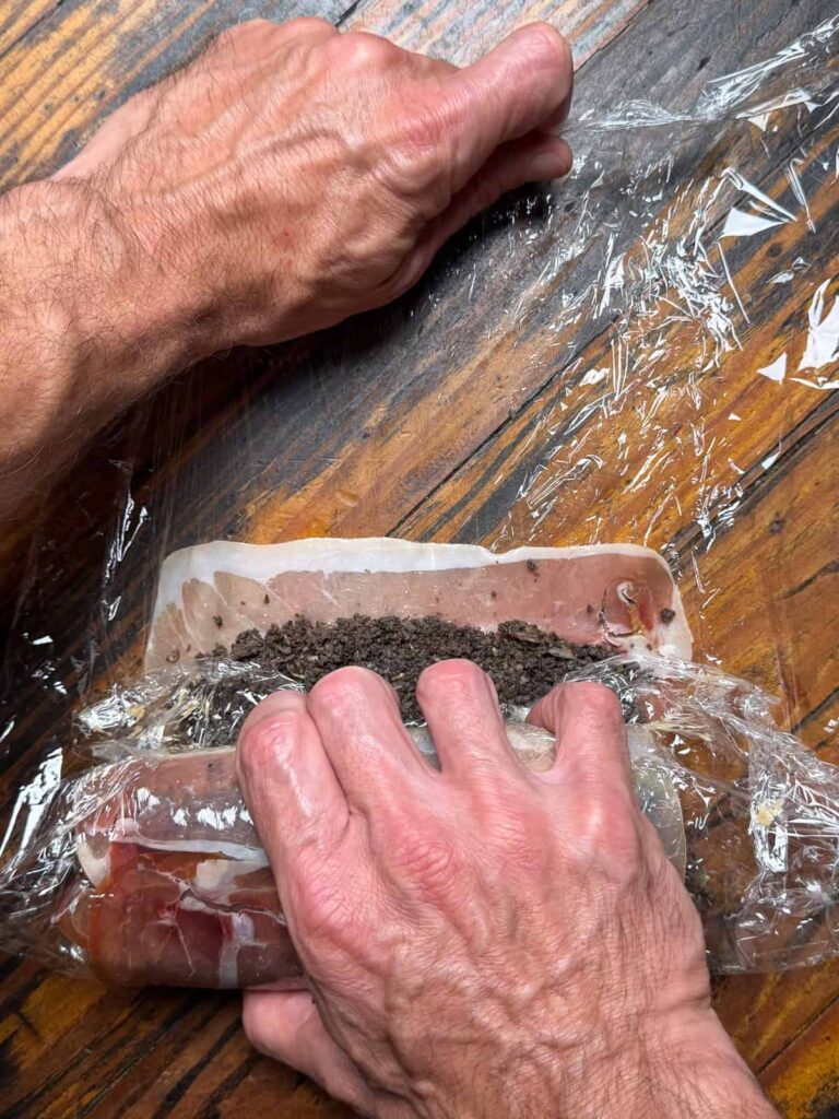 rolling venison in mushrooms and prosciutto.