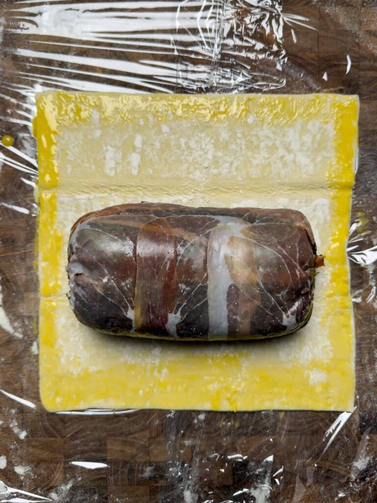 venison wellington resting on puff pastry.
