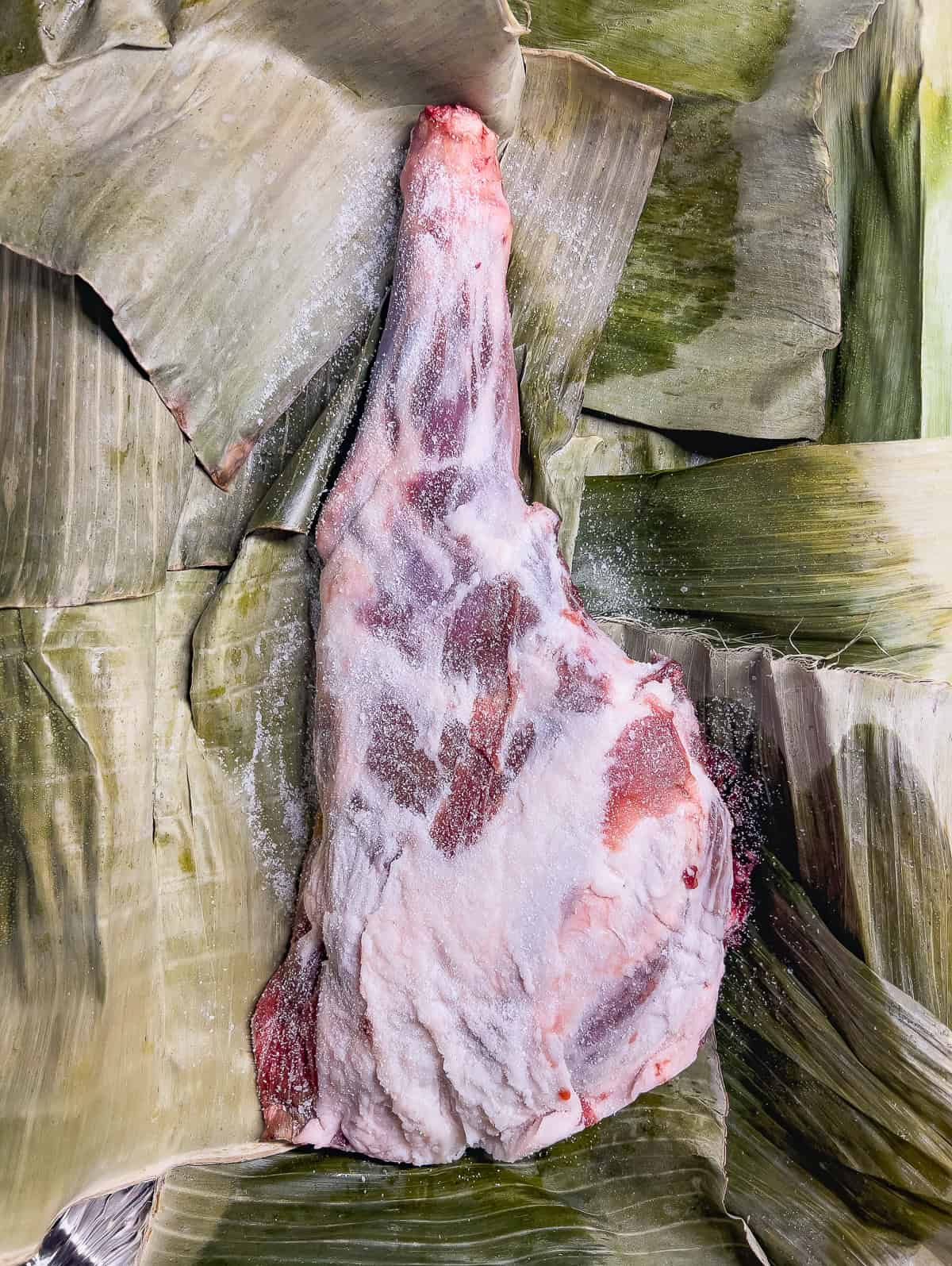 Raw pork shoulder in banana leaves