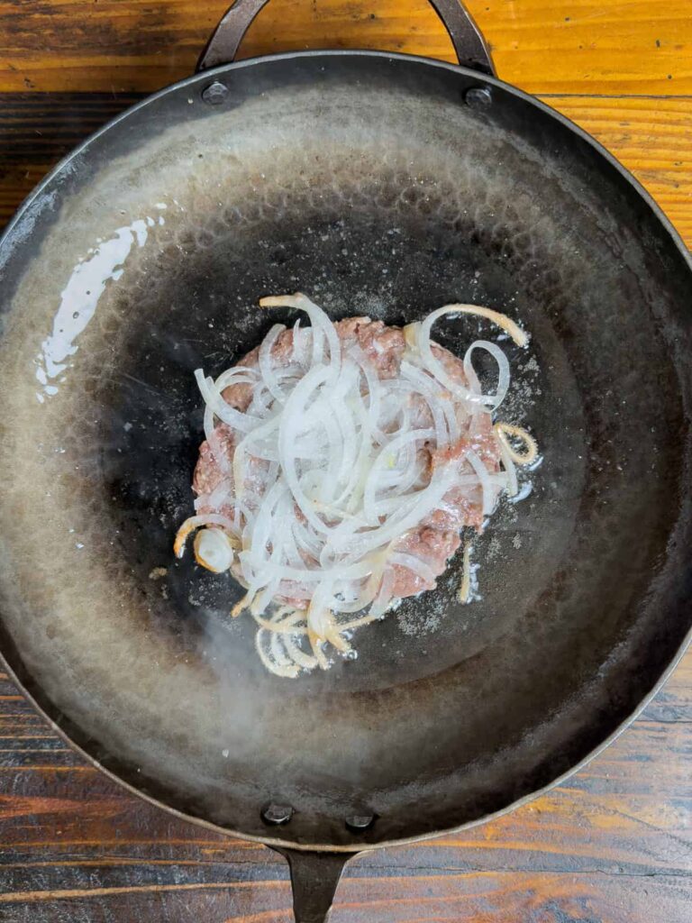 Oklahoma onion burger in a skillet.