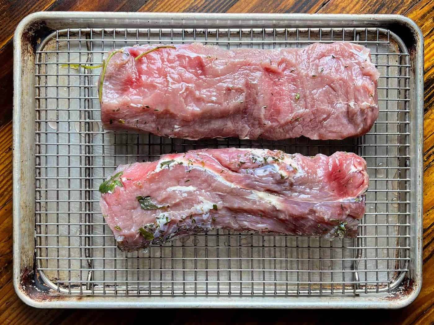 Pork loins drying on a rack.