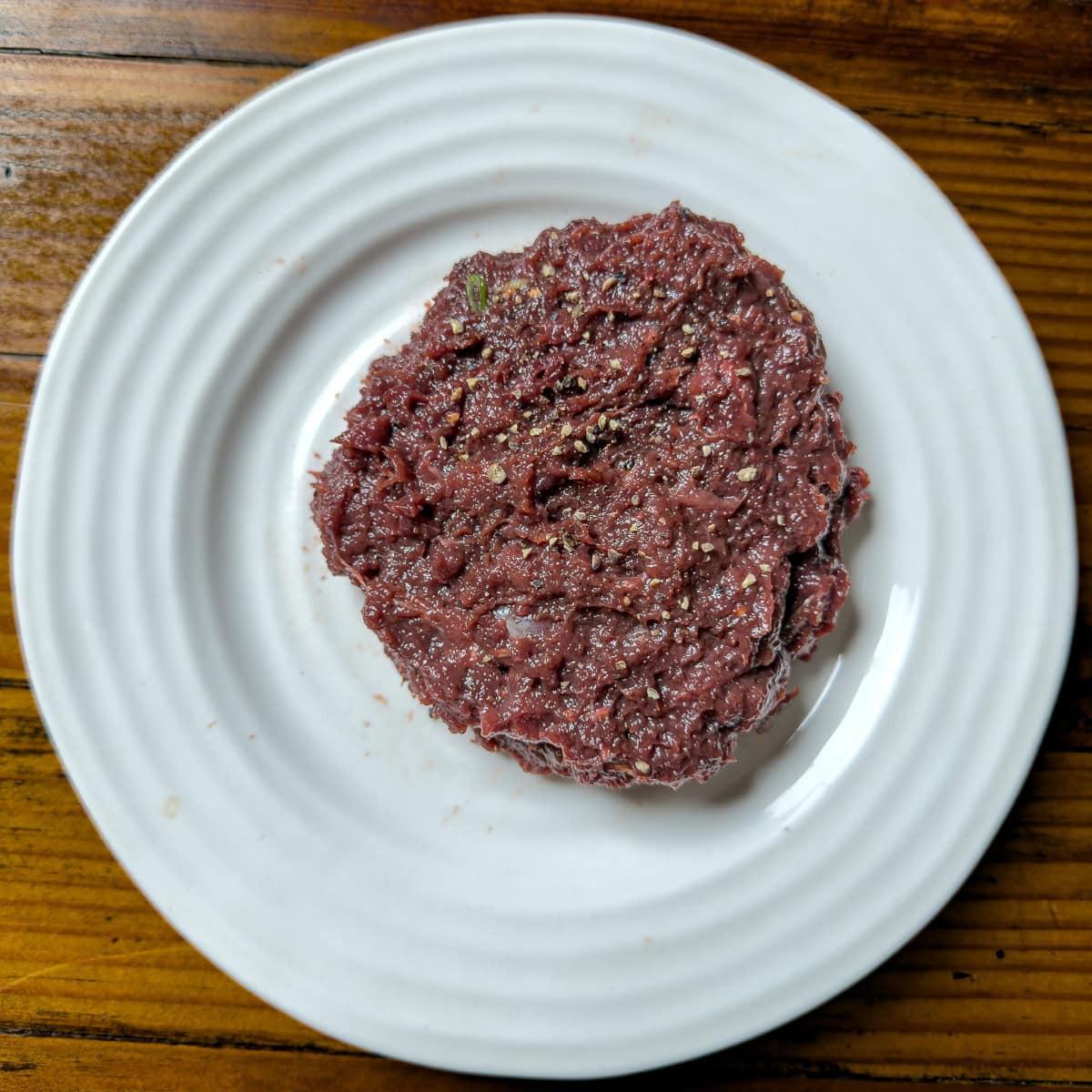 Duck burger patty on a plate.