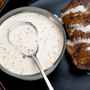 Alabama White sauce on a plate with rolled pork belly.