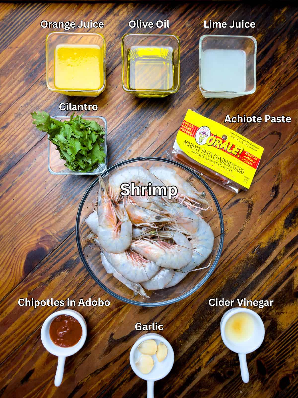 Ingredients for grilled Mexican shrimp on a wooden table.