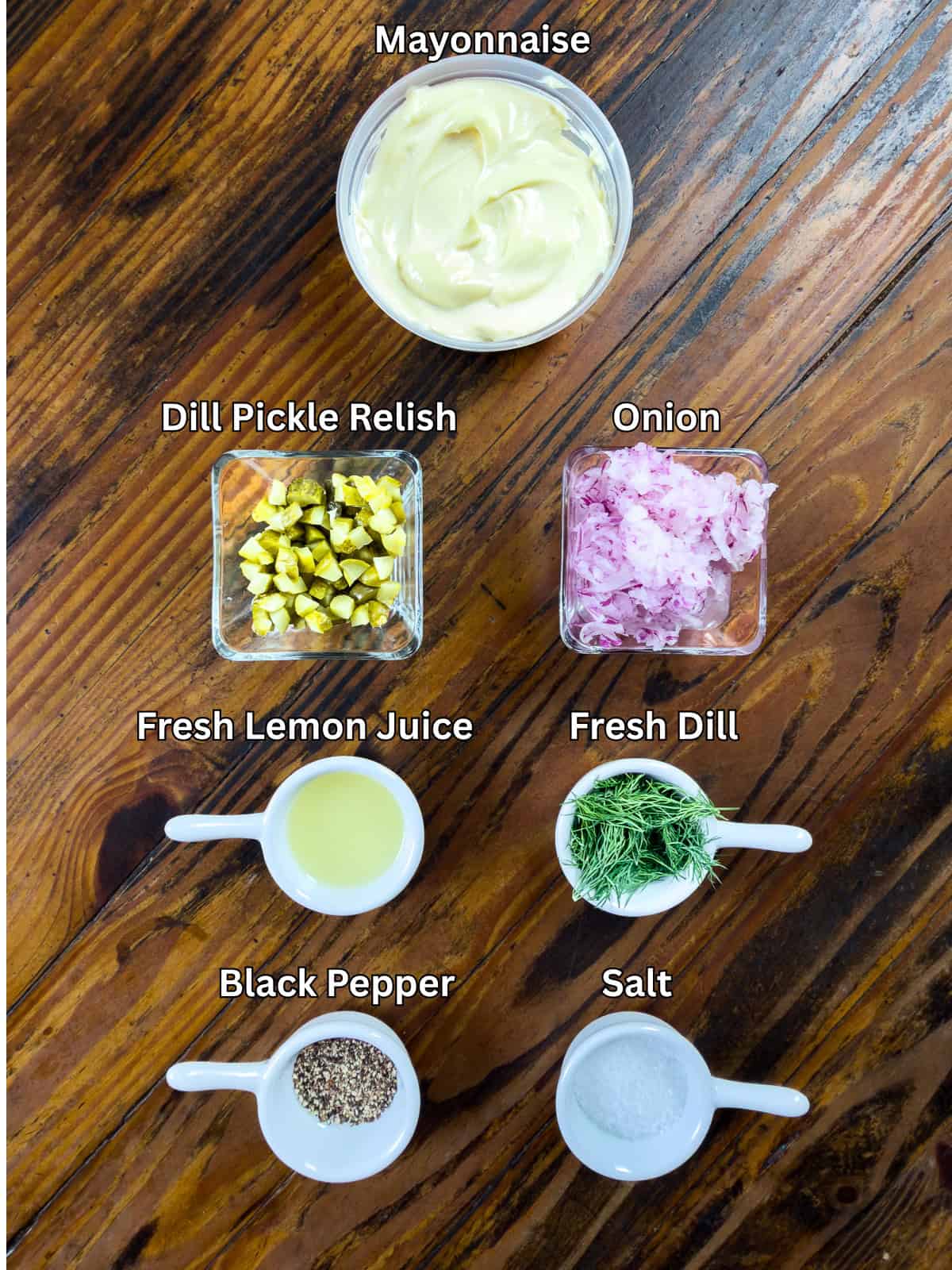 Tartar sauce ingredients sitting on a wooden table.
