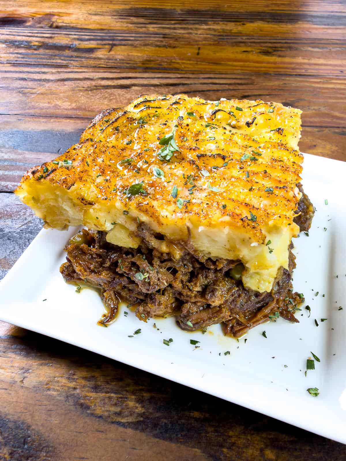 A slice of venison shepard's pie on a white plate.