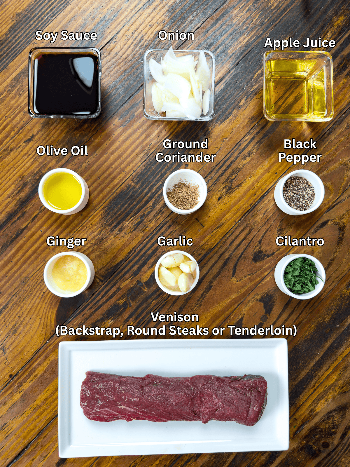 Venison marinade ingredients in dishes on a wooden table.