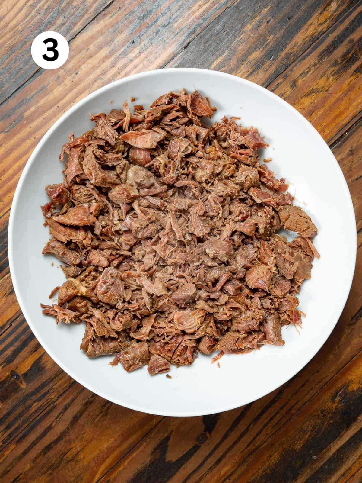 Thai-Fish-Sauce-Dressing Shredded venison stew meat in a white bowl.