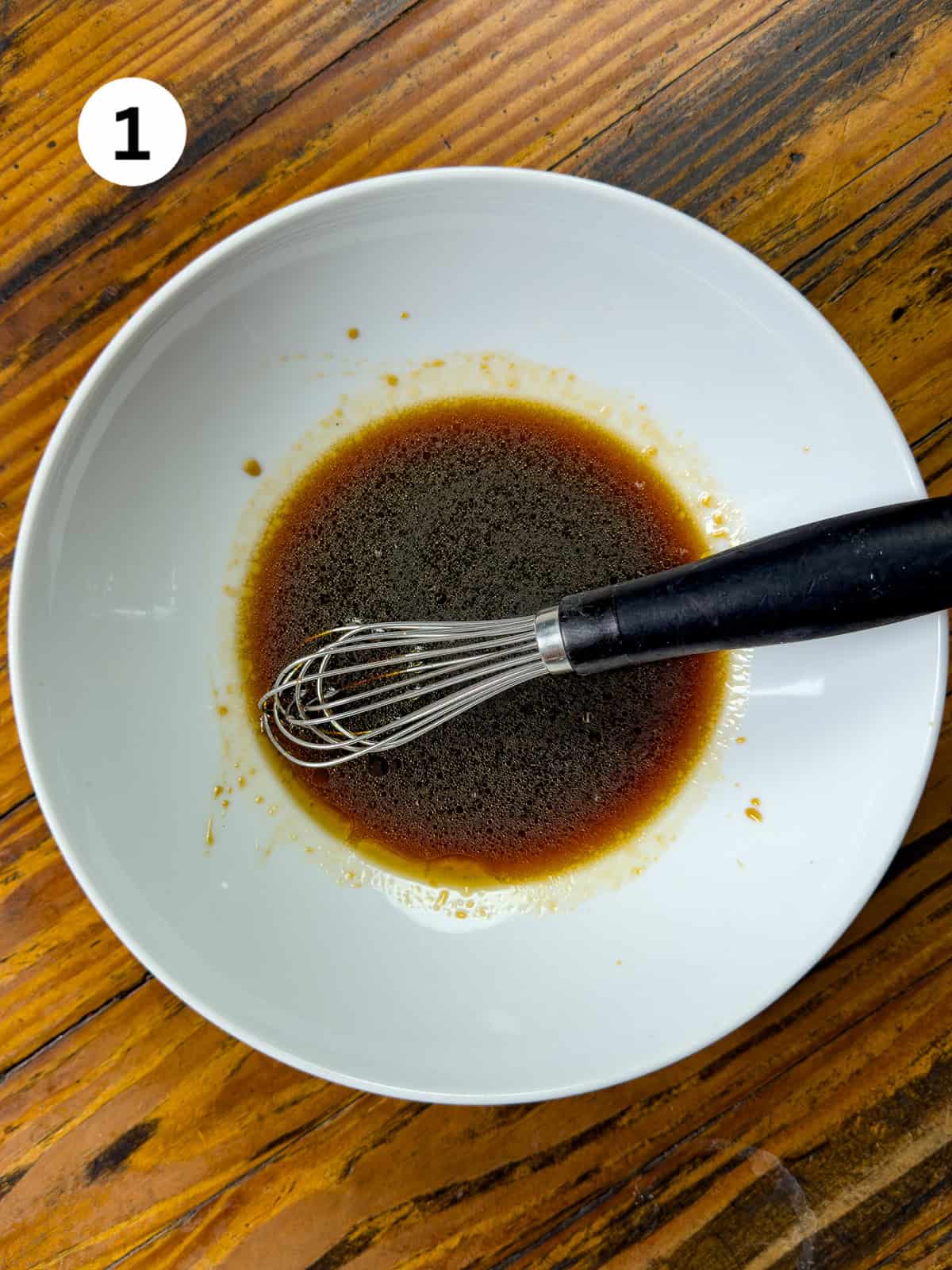 Adding wet ingredients for a Thai steak marinade in a white bowl.