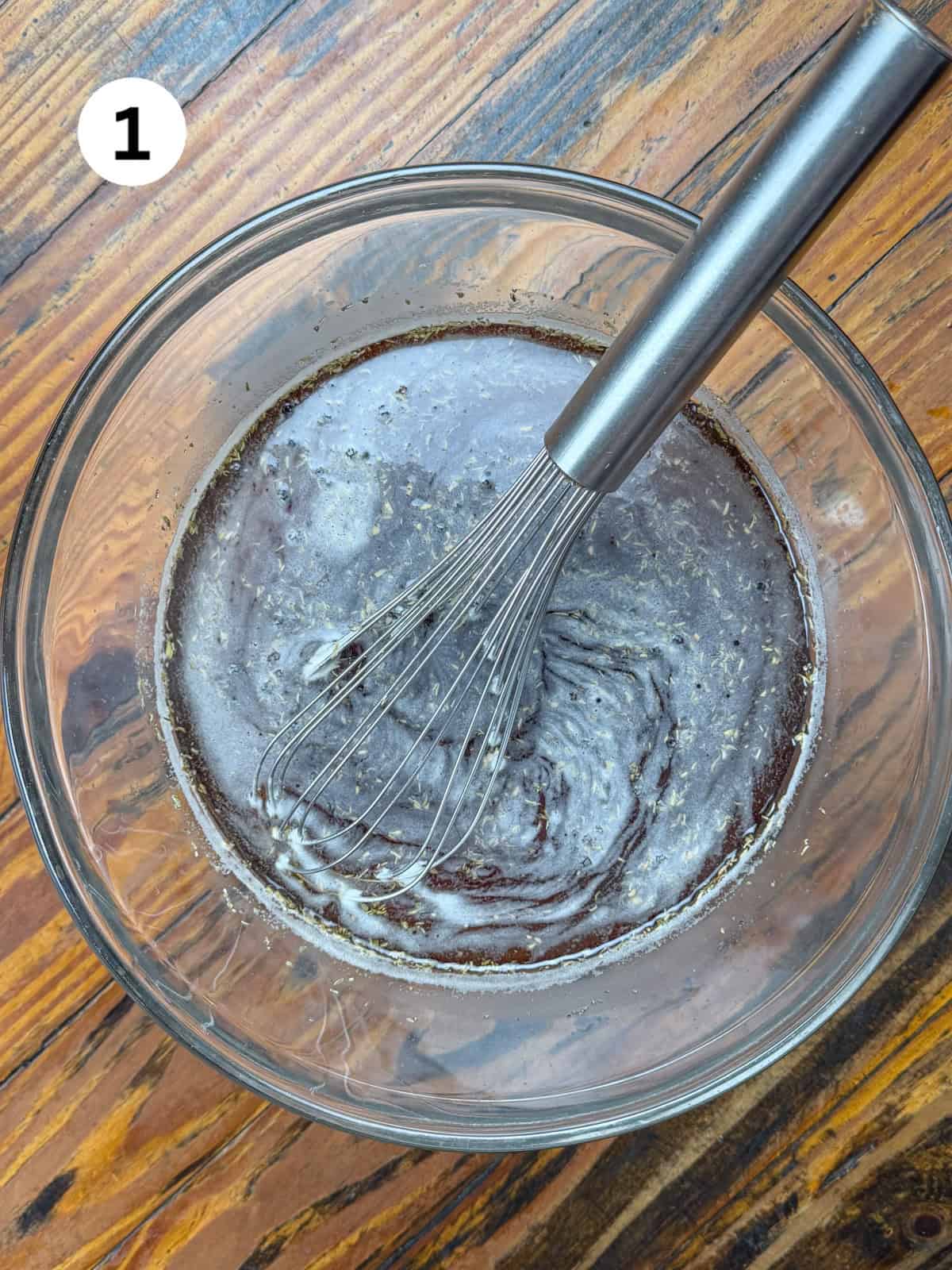 Smoked venison roast brine in a bowl with a whisk.