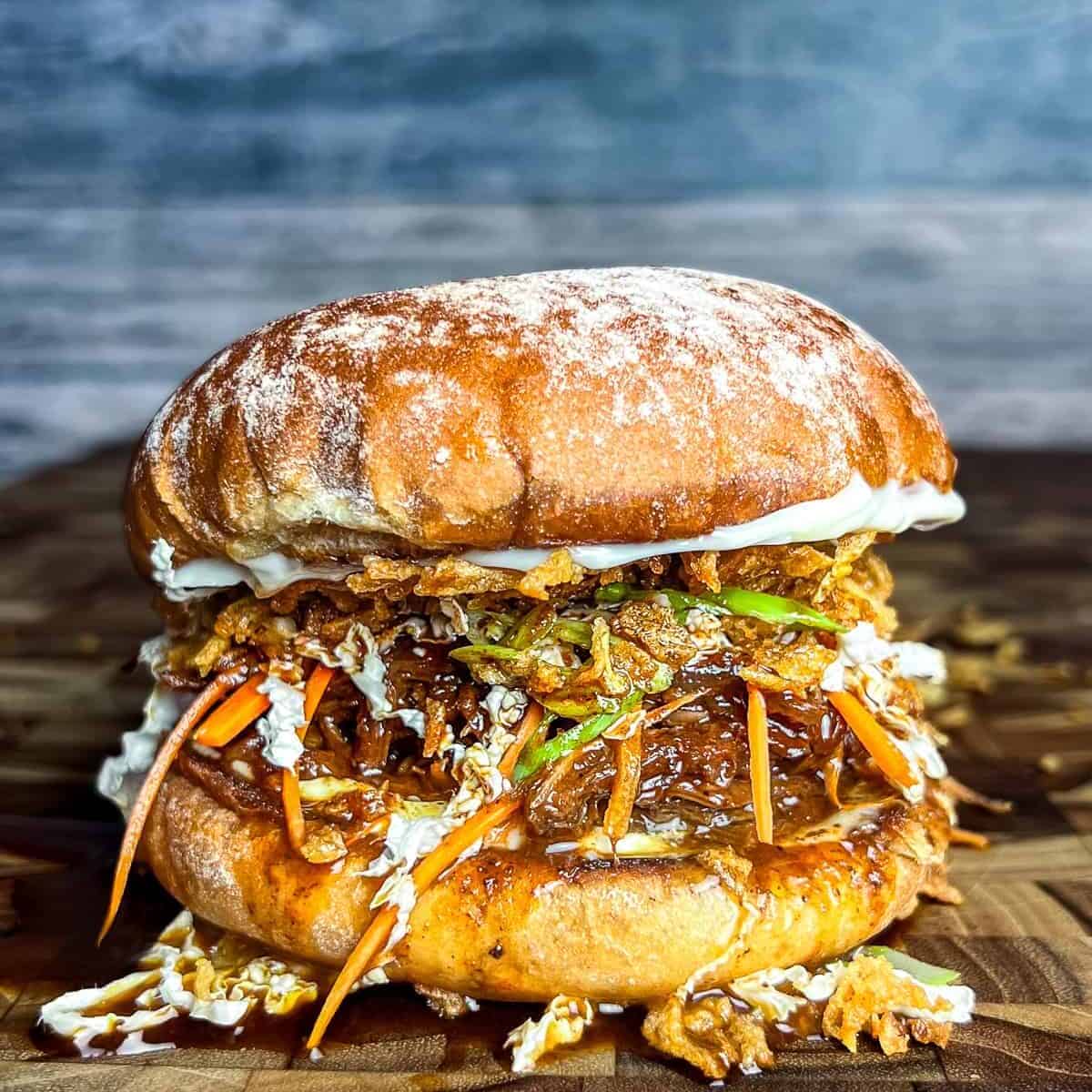 Venison roast sandwich on a wooden cutting board.